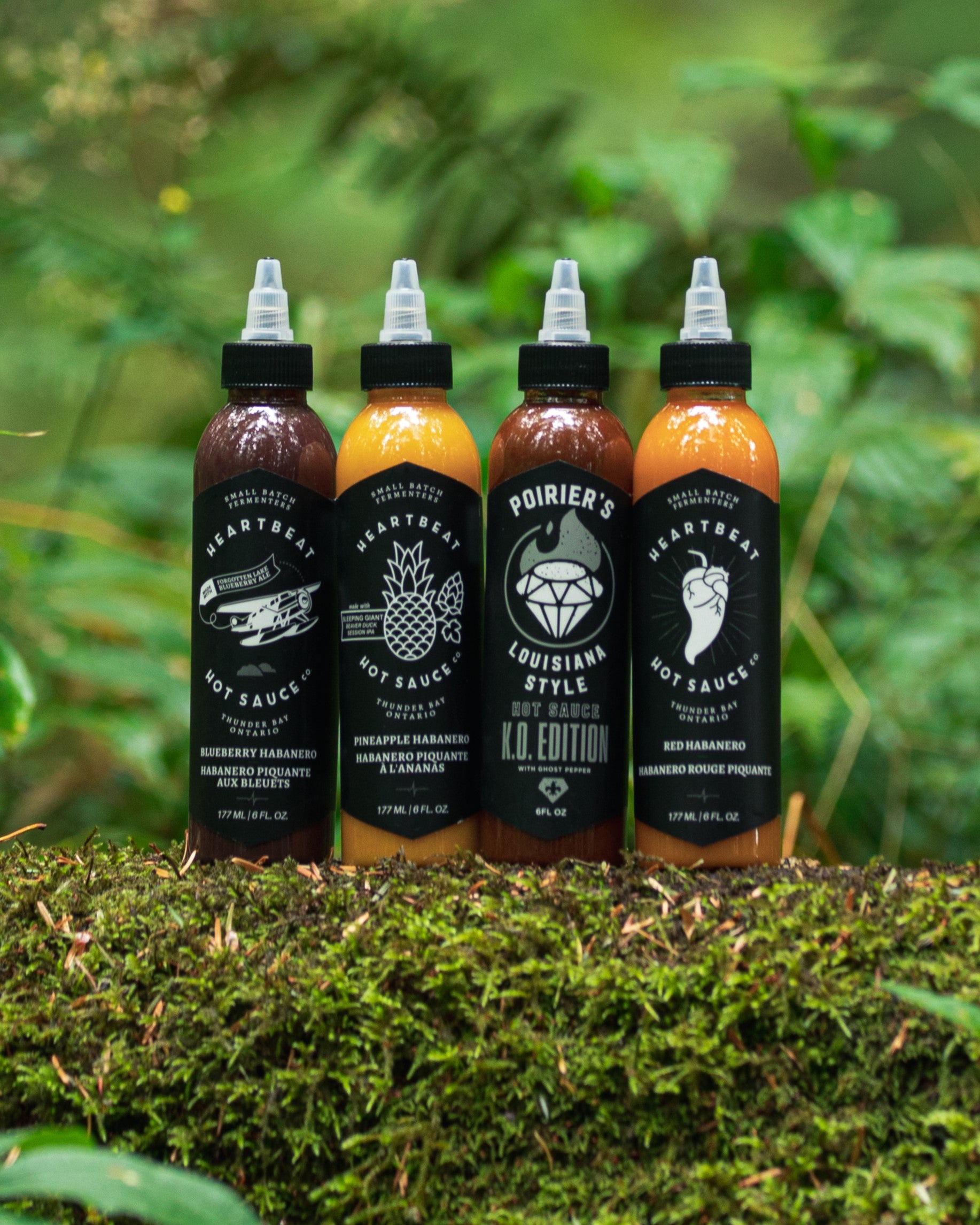 Hot Sauces on a mossy log with a forest background